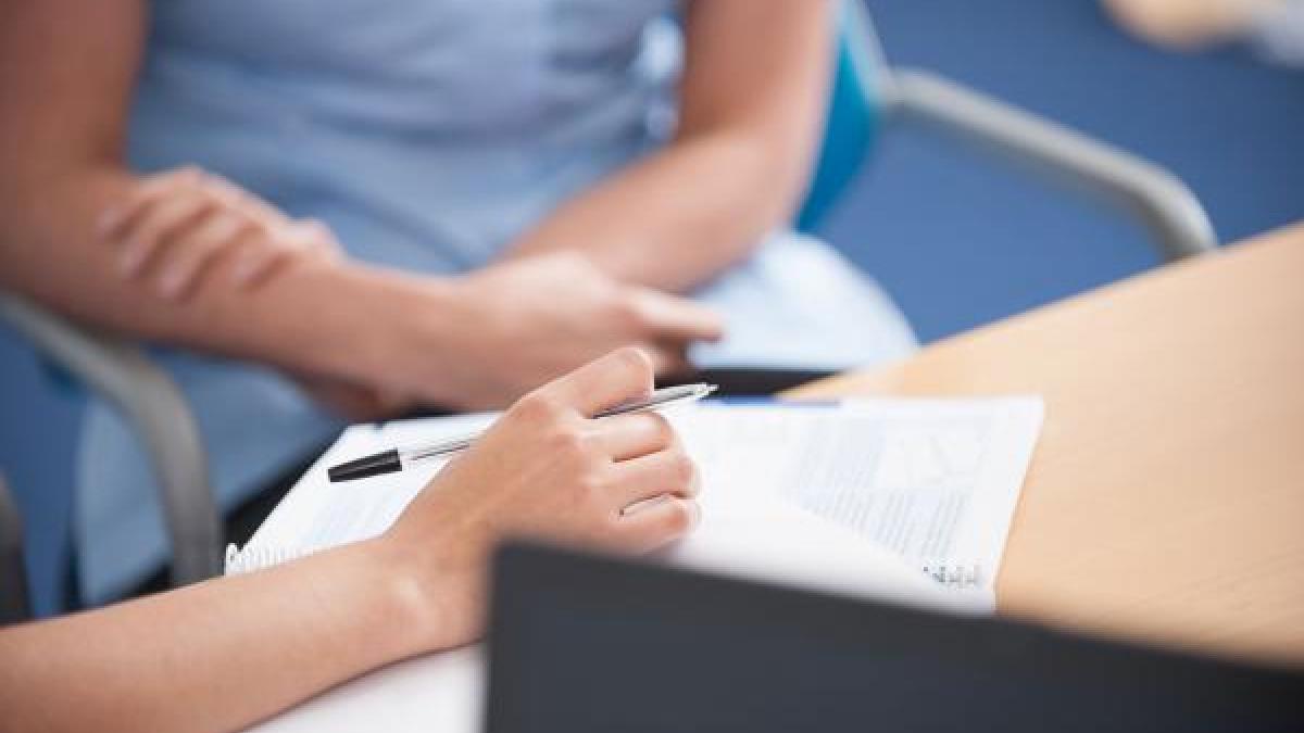 a physiotherapist making notes in a notepad