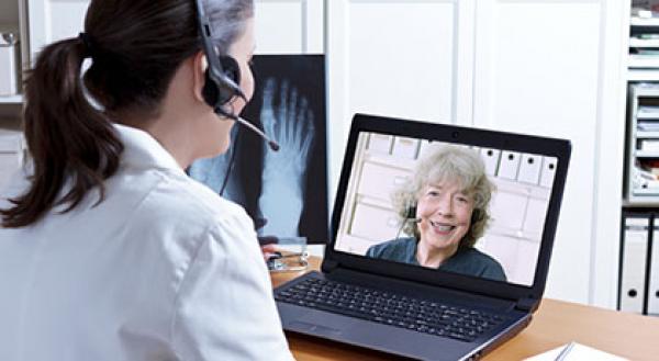 A physio takes part in a video call with a woman