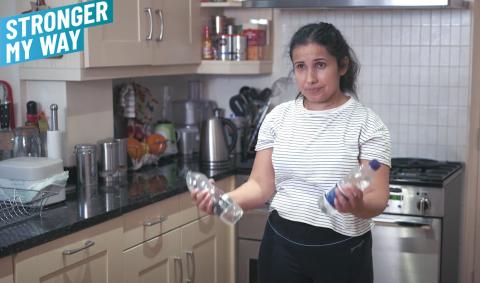 a woman doing a bicep curl with water bottles