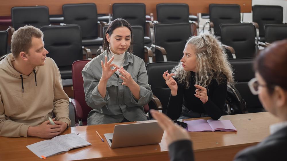 A lecturer and students communicating in sign language in the classroom