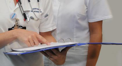 Chartered physios pointing at patient information folder