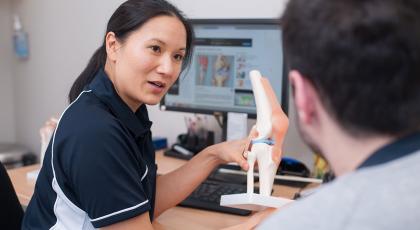 Physio showing patient a model of a joint