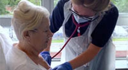 a support worker examining a patient with a stethoscope