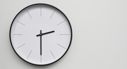 A clock on a wall representing facilities time. Shutterstock: RilakkuMaxx