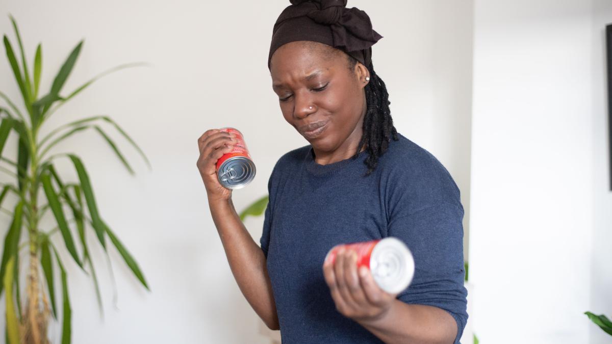 a woman doing bicep curl exercises with two cans of soup