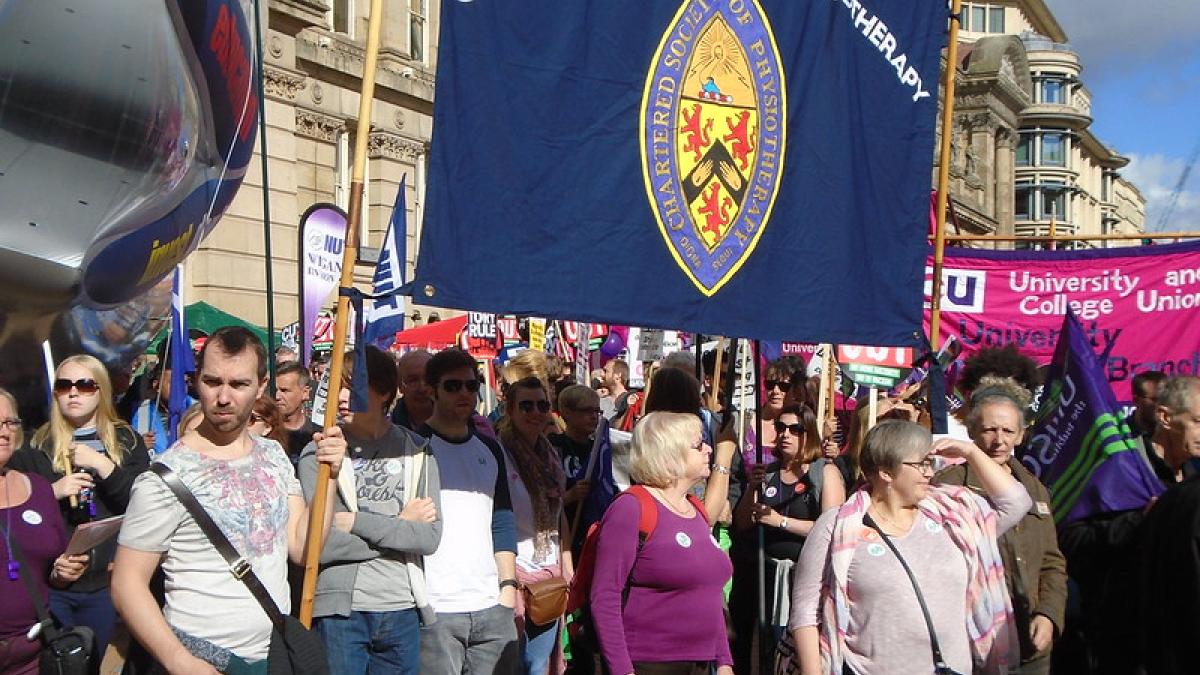 Members stand together beneath a CSP banner at a packed march