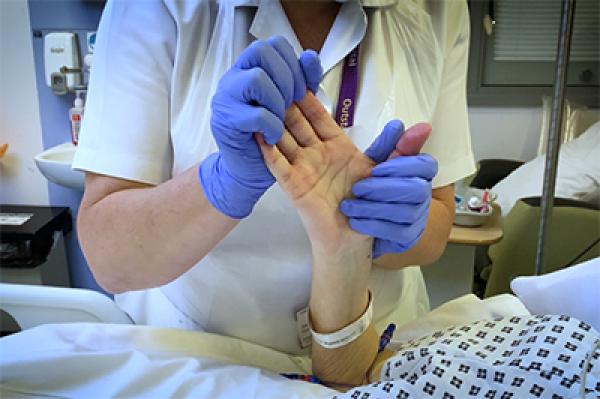 a physio tending to a patient in a hospital bed A physio tending to a patient in a hospital bed