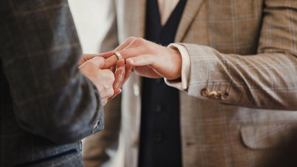 Two men exchanging rings during a ceremony