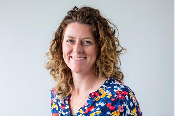Photo of a woman in a multi-coloured top on a white background