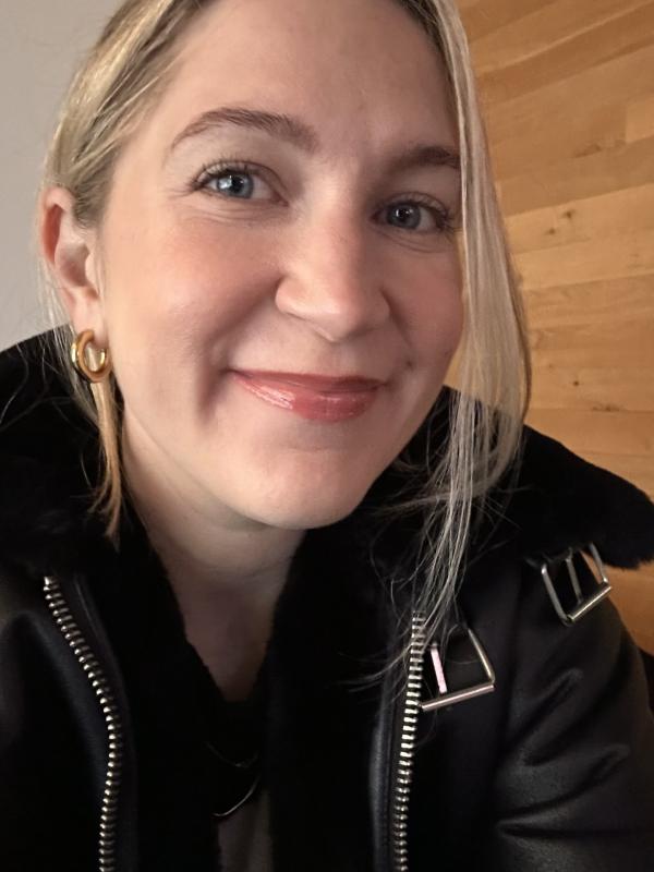 a close up of a woman with blonde hair in a black jacket