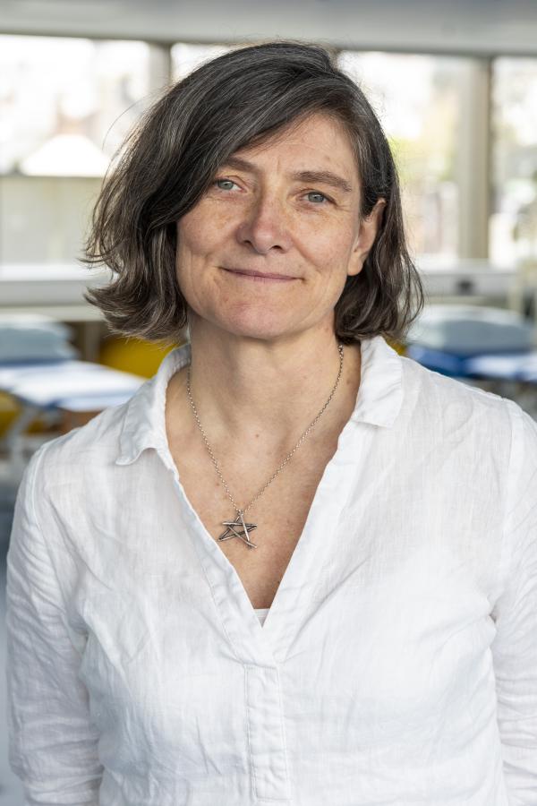 Woman in a white top with short brown hair