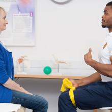 Physiotherapist demonstrating back pain exercises with a patient
