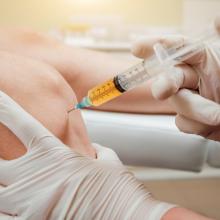A healthcare professional administering a PRP injection to a patient's knee