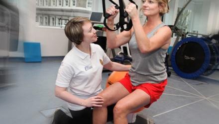 Physio guiding a woman through exercises
