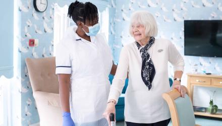 Physio with smiling elderly patient in care home