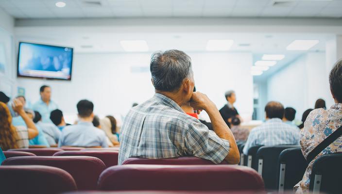 Patients sit in a waiting room