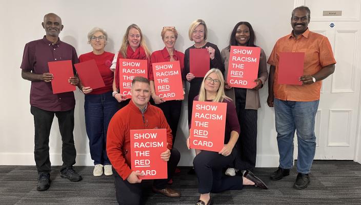 CSP council members standing in group holding red cards for wear red day