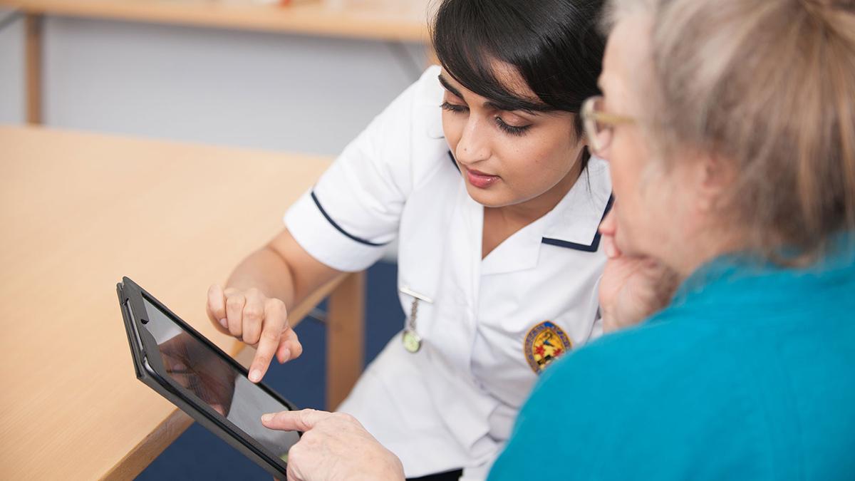 Two physios looking at a page on an ipad