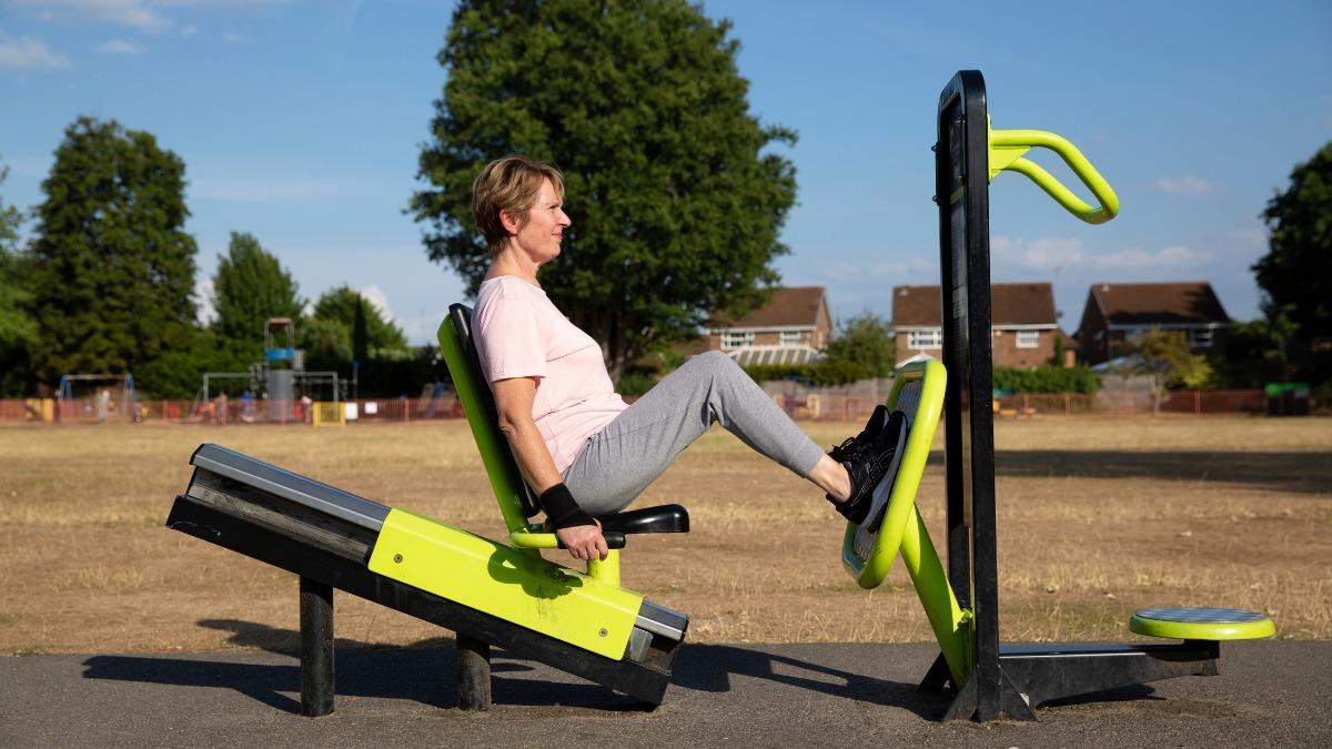 A woman on a leg press machine at an outdoor gym