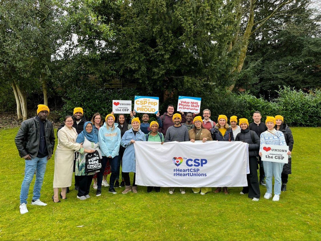 A group of Equality Reps standing outside after a training session. They are holding a variety of banners and signs promoting the CSP and Trade Unions.