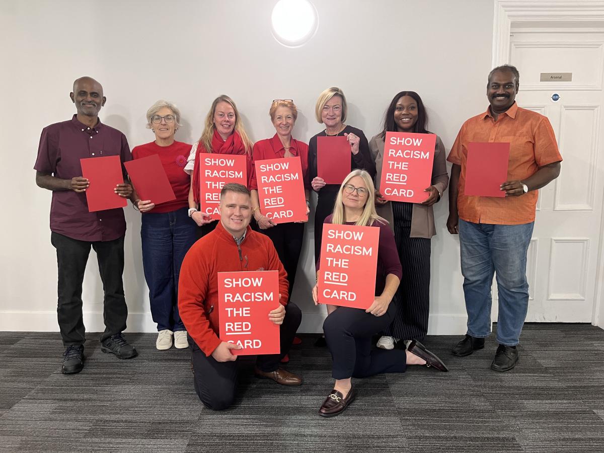 CSP council members standing in group holding red cards for wear red day